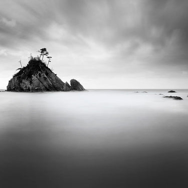 Coastal canvas art print featuring rocky island scene by Praxis Studio, branded Feeling at Home, with vibrant ocean and island details.