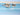 Coastal canvas art print of moorings at low tide by Penny Craig Trewin, featuring a serene seaside scene with boats and calm water.