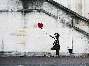 Street scene canvas art print featuring graffiti attributed to Banksy, created by Feeling at Home, showcasing vibrant urban street art.