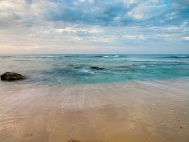 Sandy beach photography canvas art print by Frank Assaf, featuring a serene beach scene with sand and waves, by Feeling at Home.