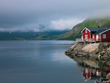 Fishing huts on the waterfront in Lofoten, Norway, depicted in a Frank Assaf canvas art print by Feeling at Home.