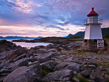 Lighthouse on the Norwegian coast in Lofoten, framed as a Feeling at Home art print by Frank Assaf, showcasing coastal scenery.