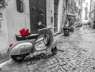 Canvas art print by Feeling at Home showing an old scooter with roses on a narrow Rome street, captured in a Frank Assaf photograph.