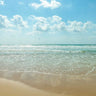Coastal canvas art print by Frank Assaf depicting a beautiful beach with cloudscape, suitable for home decor from Feeling at Home.