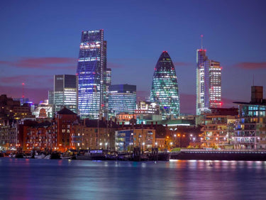 London skyline over the River Thames art print by Feeling at Home, featuring a cityscape with iconic landmarks in vibrant colors.