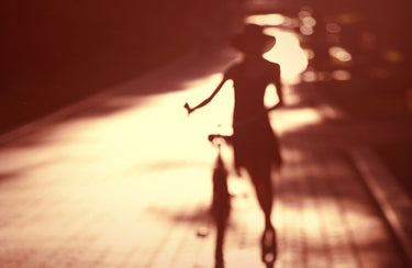 Woman shadow bike photography canvas art print by Feeling at Home, showcasing a silhouette of a woman riding a bike.