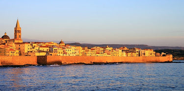 Coastal canvas art print of Alghero ramparts at sunset by Feeling at Home, featuring vibrant colors and scenic seaside views.