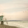 Lifeguard station at dawn decorative canvas art print by Feeling at Home, featuring a serene beach scene with vibrant sunrise colors.