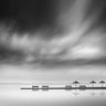 Feeling at Home coastal canvas art print featuring four benches and three umbrellas, showcasing a relaxing seaside scene.