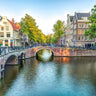 Amsterdam canal cityscape photography canvas art print by Frank Assaf, featuring a picturesque canal scene in vibrant colors.