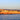 Coastal canvas art print of Alghero ramparts at sunset by Feeling at Home, featuring vibrant colors and scenic seaside views.